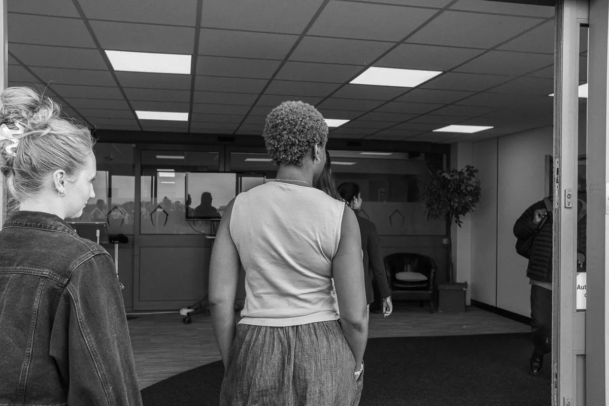 Black and white photo of people walking into the church lobby through the main doors